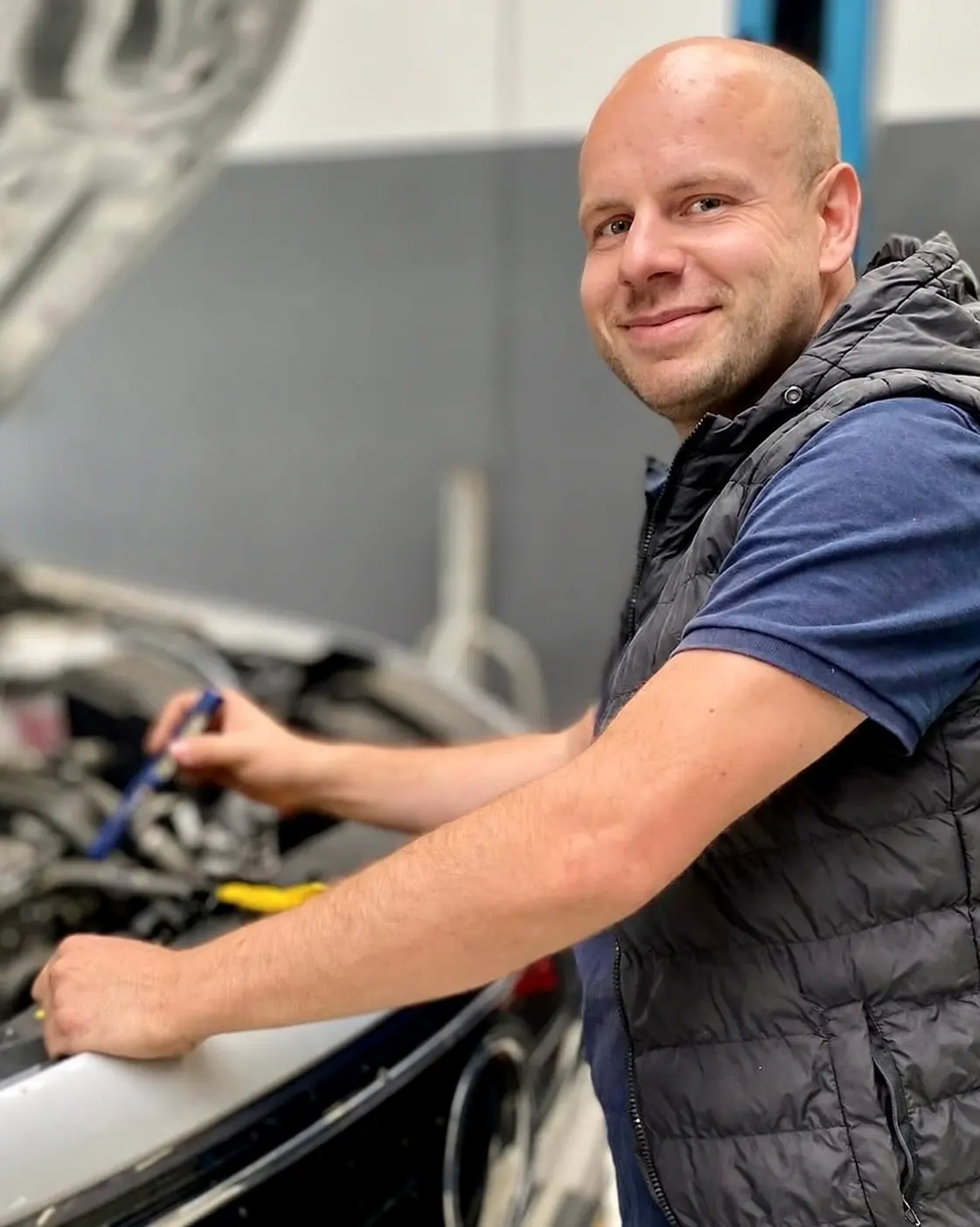 Roy Maas aan het werk onder de motorkap van een auto